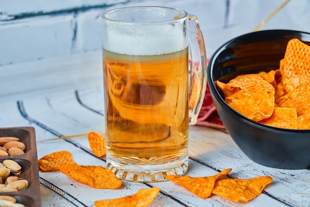 Verschiedene snacks, pommes und ein glas bier auf dem