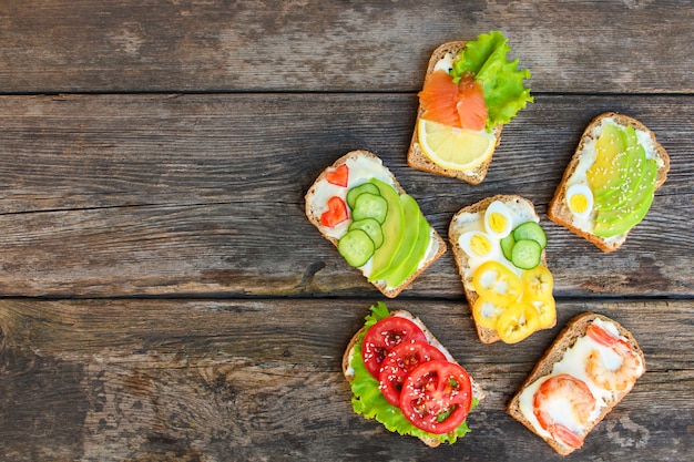 Von den verschiedenen sandwichen auf dem alten hölzernen hintergrund. Premium Fotos
