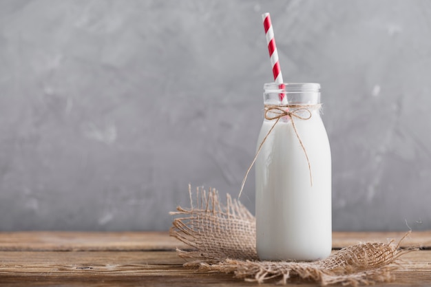 Vorderansichtflasche milch mit stroh Kostenlose Fotos