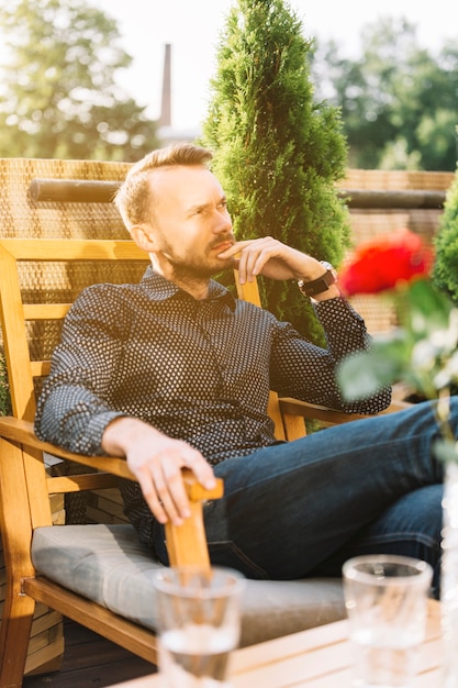 Vorgesehener mann  der im balkon  sitzt Kostenlose Foto