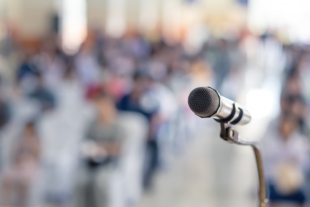 Weichzeichnung des hauptmikrofons auf stadium von student parents meeting in der sommerschule oder ereignis whit verwischte hintergrund, bildungssitzung auf stadium und kopienraum, selektiver fokus, um mikrofon voranzutreiben Premium Fotos