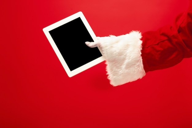 Weihnachtsmann, der laptop bereit für weihnachtszeit auf rotem