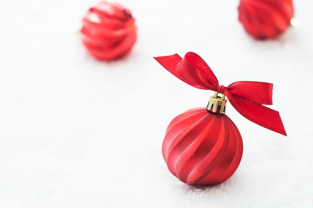 Weihnachtsroter flitter lokalisiert auf schnee. winter-grußkarte. Premium Fotos