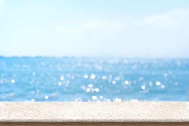 Weiße marmortischplatte mit unscharfem bokeh-meer und blauem himmel Premium Fotos