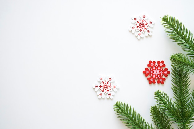 Weisser Weihnachtshintergrund Mit Tannenzweigen Und Weissen Und Roten Schneeflocken Premium Foto