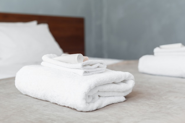 Weißes tuch auf bett im gästezimmer für hotelkunden Premium Fotos