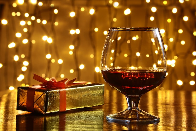 Whisky, kognak, weinbrand und geschenkbox auf holztisch. feieraufbau auf dem licht Premium Fotos