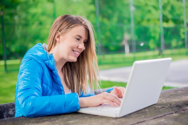 Wunderschöne Junge Brünette Mädchen Mit Ihrem Laptop In Sunlit Park Kostenlose Foto