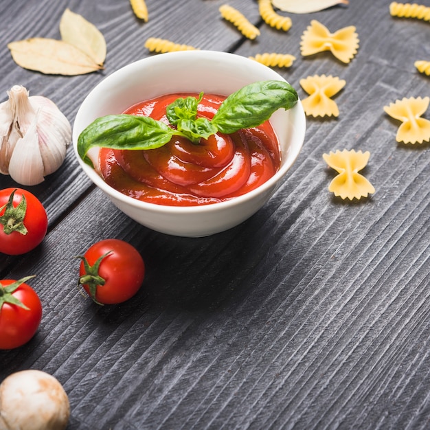 Zubereitete frische tomatensauce mit basilikumblatt auf tabelle Kostenlose Fotos