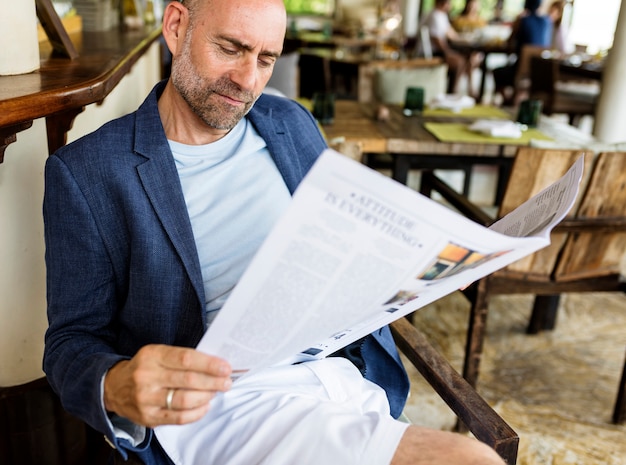 Zufälliger mann, der eine zeitung an einem restaurant liest Premium Fotos