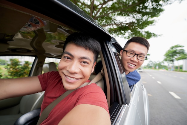 Zwei Asiatische Manner Die In Auto Auf Strasse Fahren Und Heraus Schauen Und Fahrer Der Selfie Nimmt Kostenlose Foto