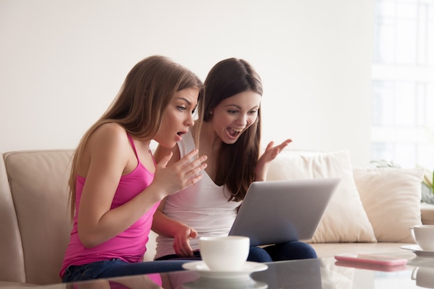 Zwei frauen schockiert mit rabatten beim online-verkauf Kostenlose Fotos