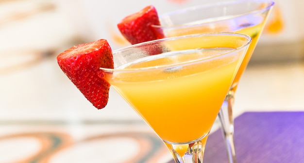 Zwei gläser bellini-cocktail mit prosecco, erdbeer-dekor, italienische bar Premium Fotos