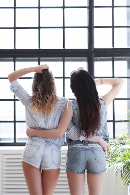 Zwei junge frauen hängen zusammen rum Kostenlose Foto