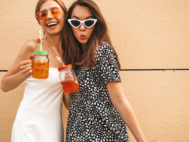 Zwei junge schöne lächelnde hippie-mädchen in den modischen sommerkleidern. Kostenlose Fotos
