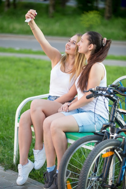 Zwei Mädchen Die In Einer Bank Mit Fahrrädern Premium Foto 