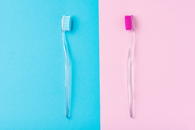Zwei plastikzahnbürsten in pastellblau und pink, flach aufgelegt Premium Fotos