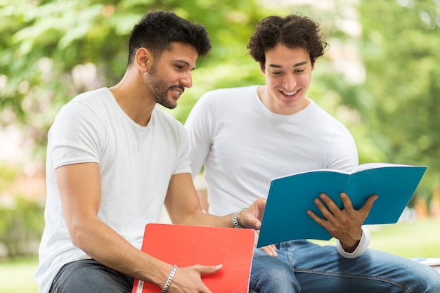 Zwei Studenten Die Zusammen Auf Einer Bank Sitzen Im Freien Studieren Premium Foto