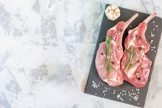 Zweiteiliges rohes fleisch auf schneidebrett mit rosemary Premium Fotos