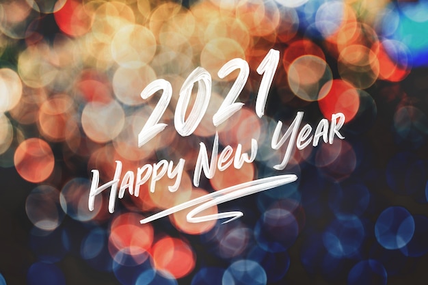 2021 happy new year brush stroke handwriting on abstract festive colorful bokeh light Premium Photo