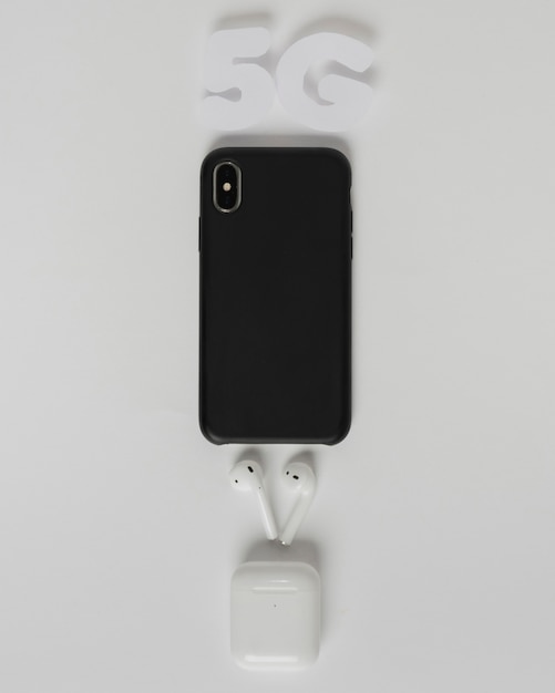 5g text above phone with earpods Free Photo