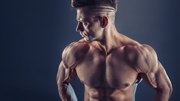 筋肉ビルド上半身裸の男性のボディービルダーを示す強い腹筋 健康的な筋肉の若い男のショット 完璧なフィット感 6パック 腹筋 腹筋 肩 三角筋 上腕二頭筋 上腕三頭筋および胸部 プレミアム写真