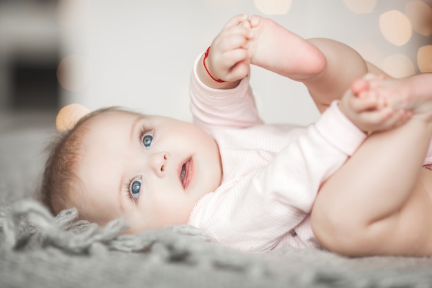 自宅の寝室でかわいい小さな赤ちゃん 屋内の幼児 6ヶ月目の子供の肖像画 愛らしいかわいい女の子 プレミアム写真