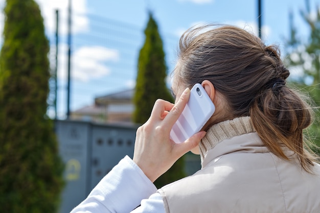 Девушка звонит через смартфон во время прогулки по улице. | Премиум Фото