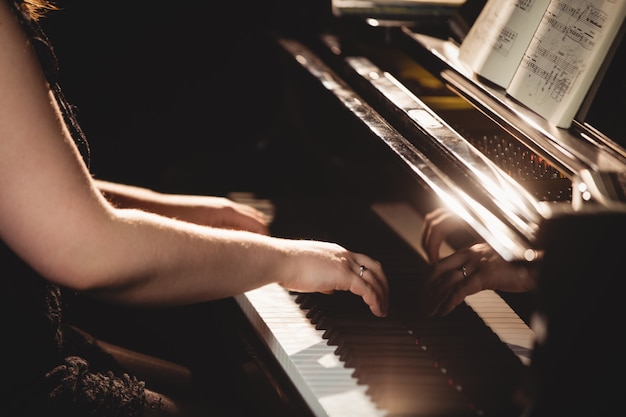 音楽スタジオでピアノを弾く女性 無料の写真