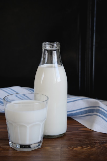 Свежее молоко в стеклянной бутылке и кружке на деревянном столе Photo ...