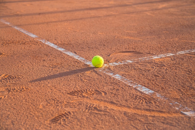 晴れた日にテニスコートの白い線の上に横たわるテニスボール プレミアム写真