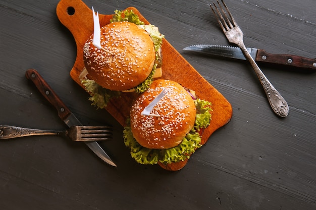 Два аппетитных, вкусные домашние бургеры рубить говядину. на деревянном столе. Premium Фотографии