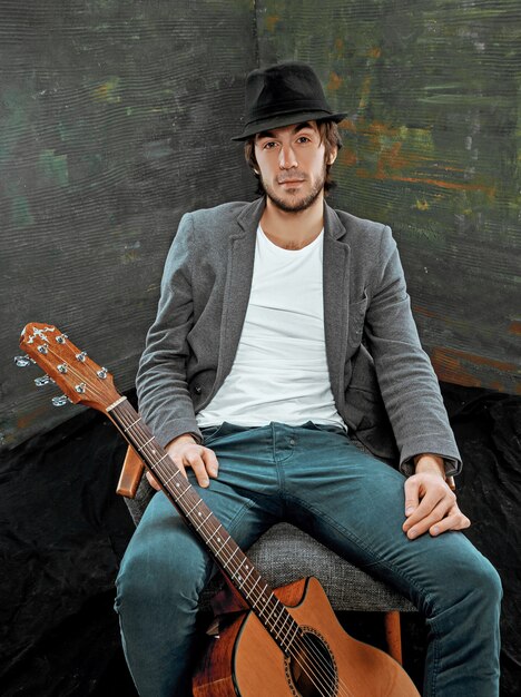 灰色のギターで座っているクールな男 無料の写真