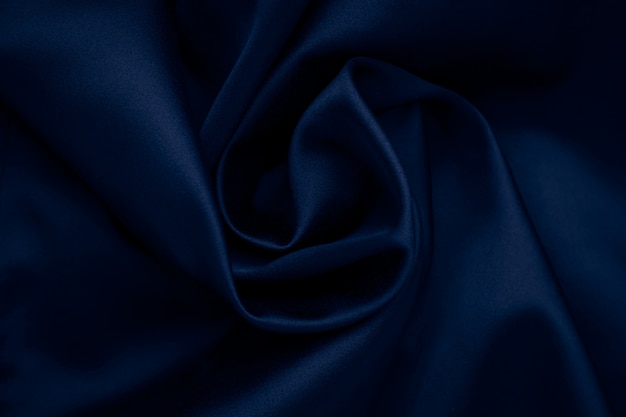 ダークブルーの波状シルクの背景 布 布の織物の抽象的な表面 サテンの壁紙 しわくちゃの素材の質感 プレミアム写真