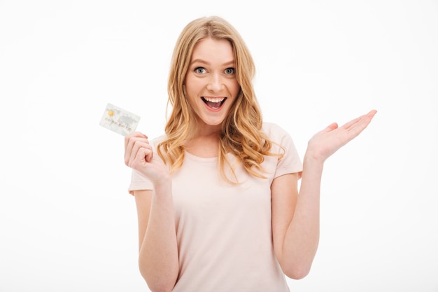 クレジットカードを保持している陽気な若い女性。 無料写真