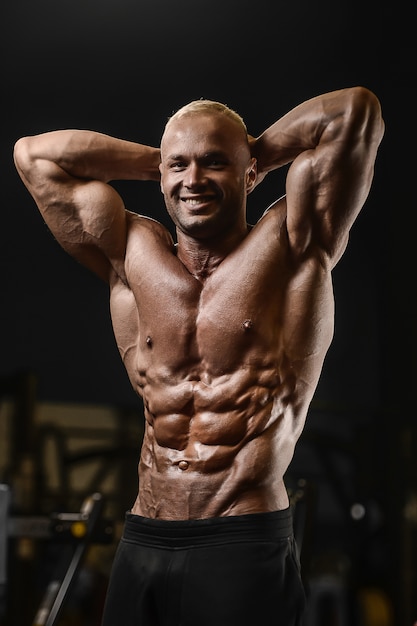 ハンサムな強い運動男性の筋肉トレーニングフィットネスとボディービルのコンセプト ジムの裸の胴体で腹筋運動を行う筋肉ボディービルダーフィットネス男をポンプ プレミアム写真