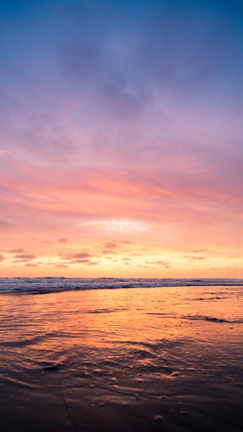 日没時にピンクの空と水域の垂直方向のショット 壁紙に最適です 無料の写真