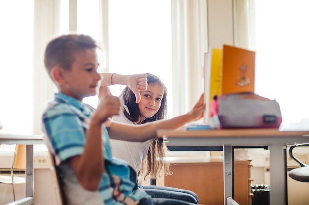 学校の机に座っている少年と少女 無料の写真