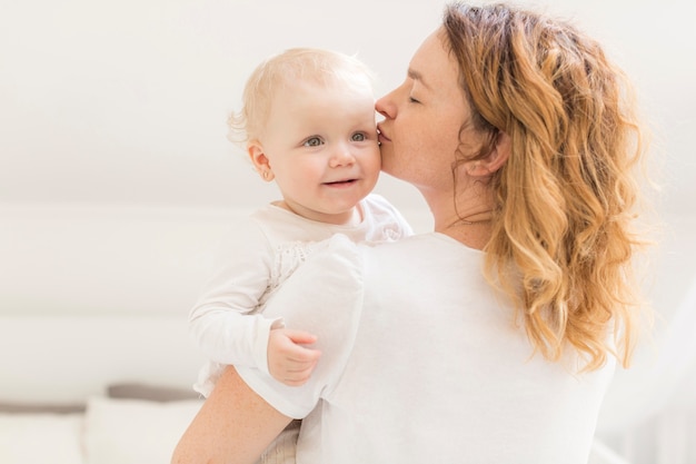 母は彼女のかわいい女の子にキス 無料の写真