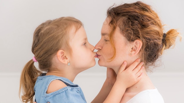 愛らしい少女が母親にキス 無料の写真