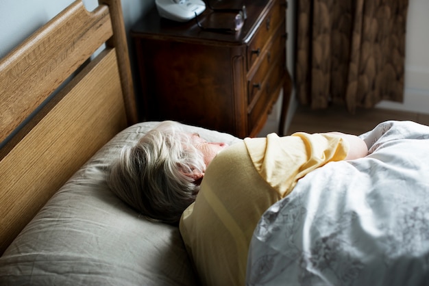 ベッドで寝る高齢者の白人女性 プレミアム写真