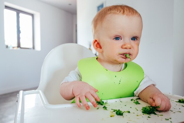 一人で柔らかい野菜を食べて面白い赤ちゃん女の子 無料の写真