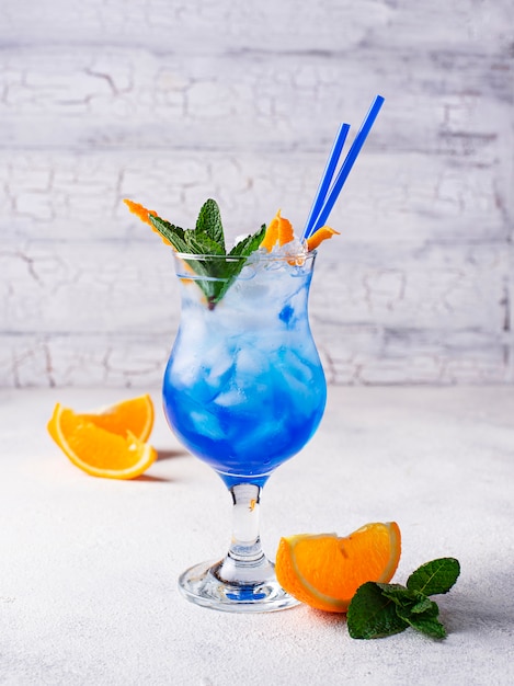 氷とオレンジの青いカクテルドリンク プレミアム写真