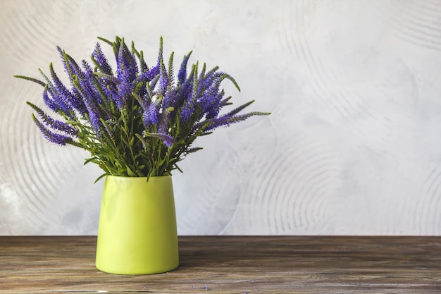 緑の花瓶に青いベロニカの花の花束 プレミアム写真