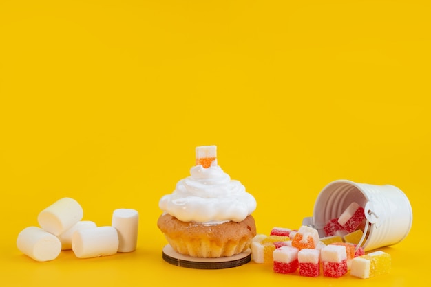 正面のキャンディーとマシュマロ 黄色のビスケットケーキ 砂糖菓子に小さなケーキ 無料の写真