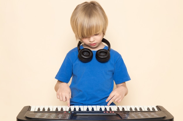 無料の写真 小さなかわいいピアノを弾く黒いヘッドフォンと青いtシャツの正面かわいい男の子