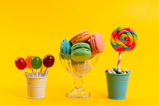 黄色い砂糖の甘い菓子キャンディーのバケツの中のキャンディーとロリポップと一緒に正面のフランスのマカロン 無料の写真