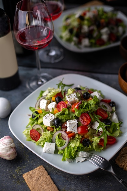 正面のギリシャ風サラダスライスした野菜のサラダトマトきゅうりのホワイトチーズと白いプレートビタミン野菜の中のオリーブ 無料の写真