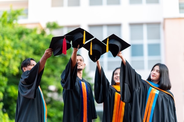 大学卒業生のグループが黒い帽子をかぶって 卒業式の日に彼らを祝福しました プレミアム写真