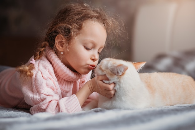 小さな女の子がペットの猫にキスをします 人間と動物の友情 プレミアム写真